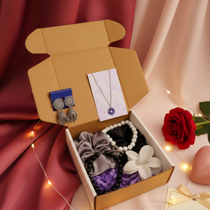 Aesthetic jewellery gift hamper with jhumka earrings, flower pendant necklace, satin scrunchies, beaded bracelet and flower hair clip arranged in a gift box.